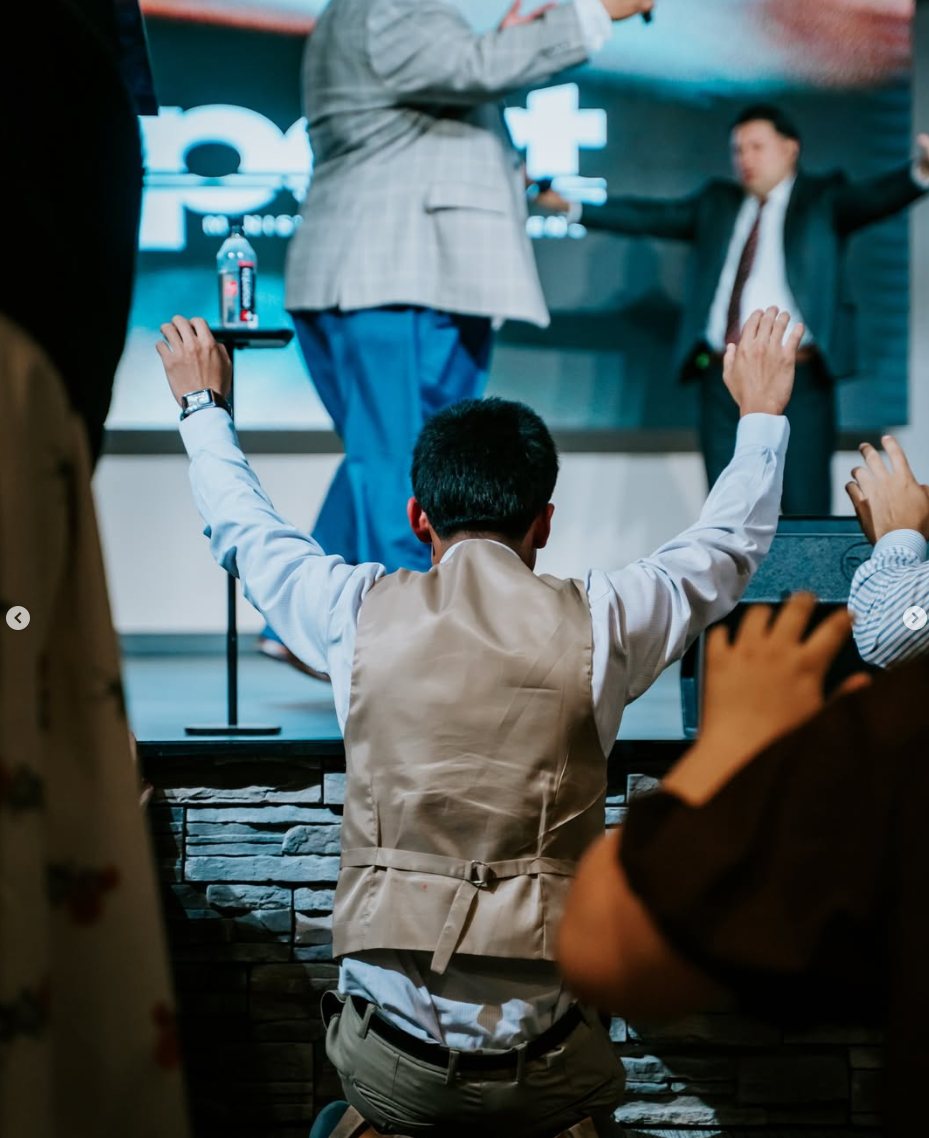A person kneeling in prayer at the altar